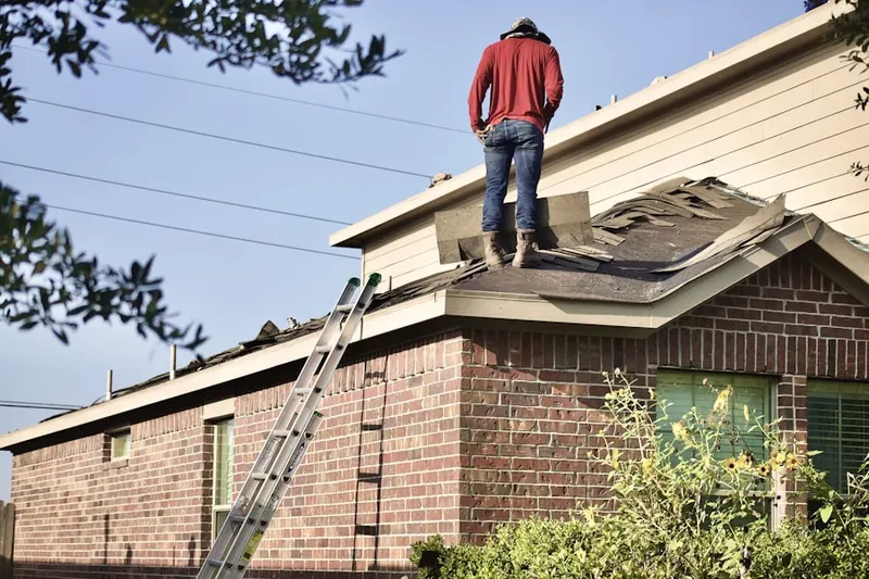 Professional roofer working on a residential roof in Fisher's Landing East